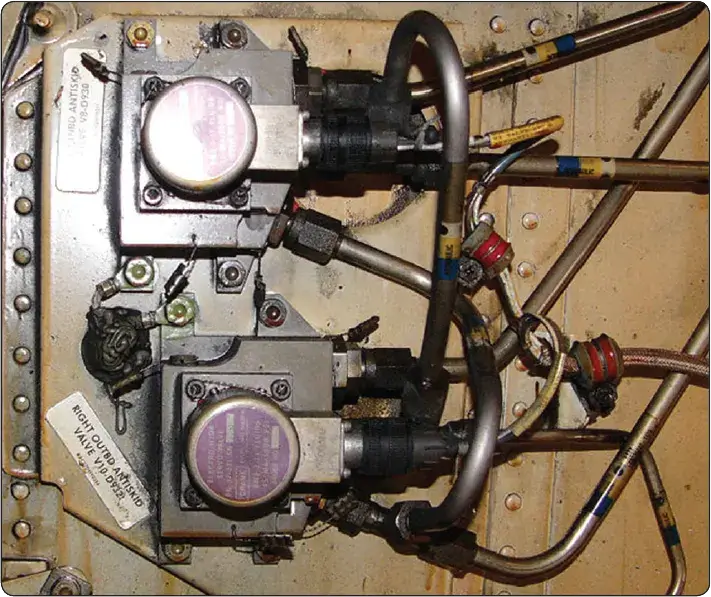 Two aircraft antiskid control valves with connected hydraulic plumbing and electrical wiring