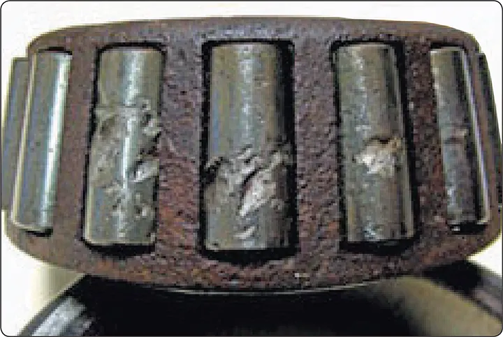 Bearing roller or raceway with spalling damage and localized areas of hardened surface loss