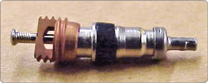 Aircraft tire valve core being removed after complete deflation before removing the tire and wheel assembly