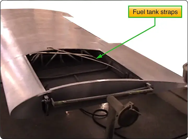 Light aircraft wing fuel tank bay at the wing root, positioned on a stand inside a paint booth