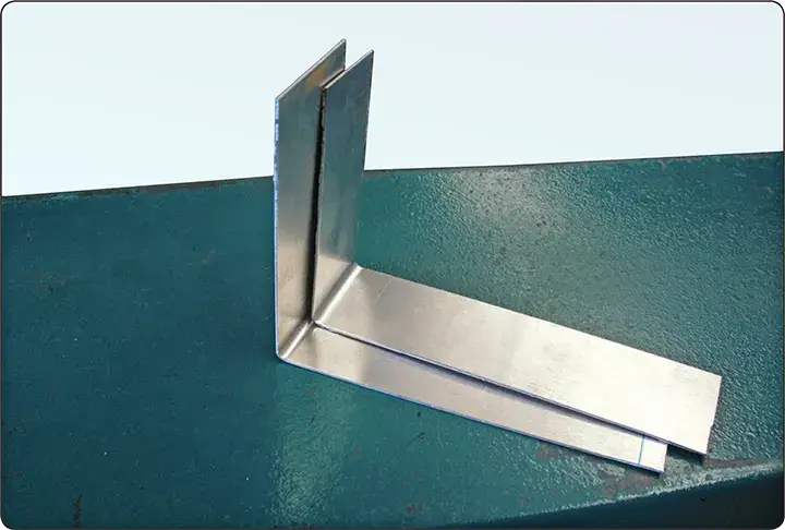 Sheet metal brake alignment checked by comparing two bent test strips