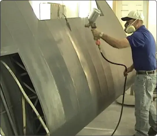 Spraying cross coats of UV-blocking primer onto aircraft fabric covering