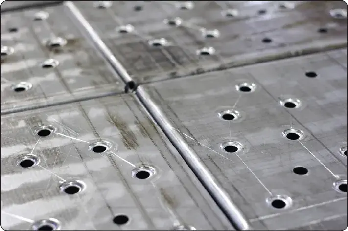 Drilled aircraft sheet metal showing accurately positioned holes for structural repair