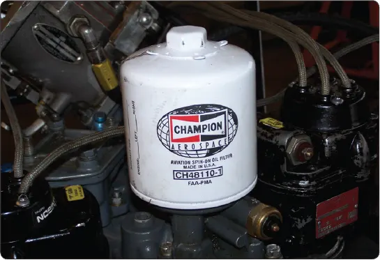 Full-flow spin-on oil filter used in an aircraft reciprocating engine lubrication system to remove contaminants from circulating oil