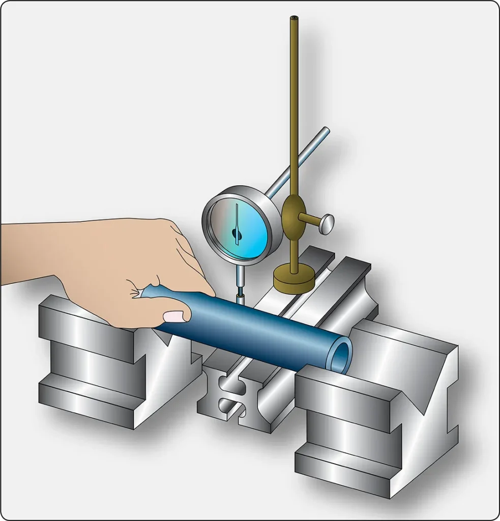Illustration showing a piston pin supported on a precision inspection setup with a dial indicator to check for bending or runout